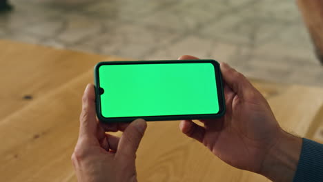 closeup businessman watching mockup phone indoors. boss hands holding cellphone