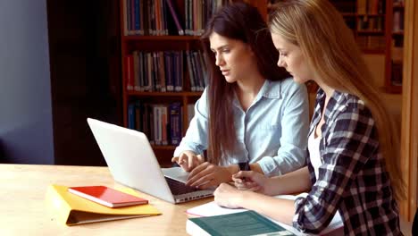 two students working on a laptop