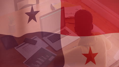 animación de la bandera nacional sobre un hombre de negocios biracial usando una computadora portátil