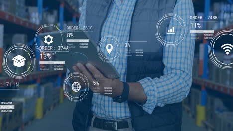 In warehouse, businessman using tablet with animation of data analytics and graphs