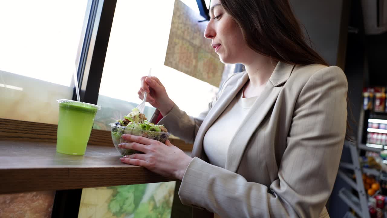 Young Woman Enjoying a Healthy Salad and Green Smoothie at a Cafe