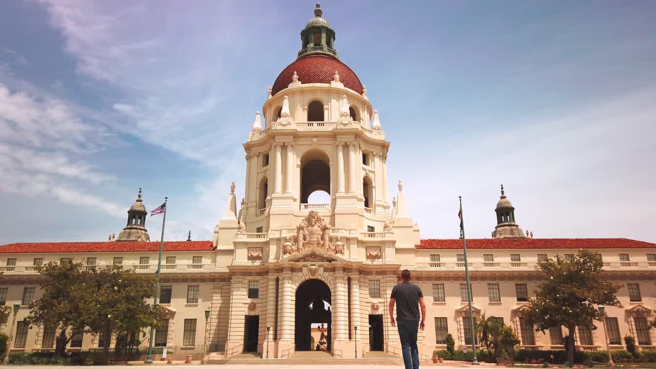 hombre caminando hacia el edificio del ayuntamiento de pasadena, tiro de ángulo bajo, en estilo renacimiento mediterráneo y español, california
