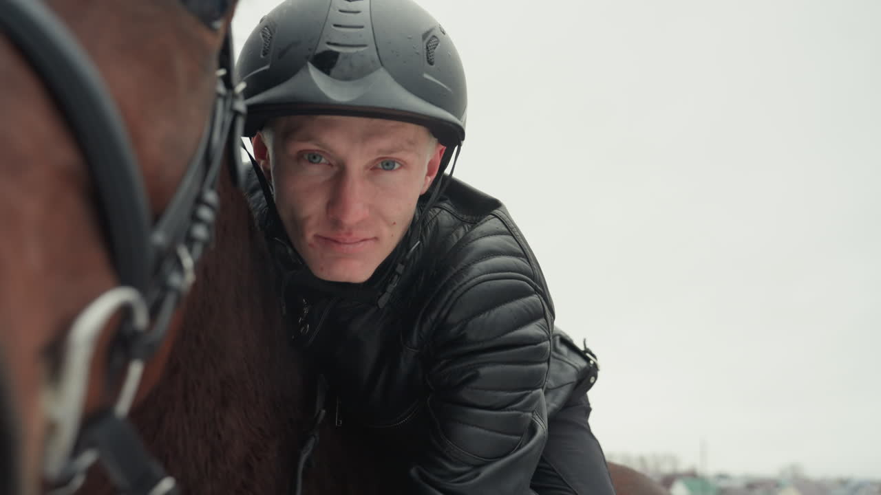 Cavaliere bianco che abbraccia dolcemente un cavallo marrone, un intimo momento di educazione in tandem trasformato in un legame terapeutico, uomo caucasico con casco che appoggia la guancia contro il fianco del cavallo, sguardo gentile e calda connessione emotiva.