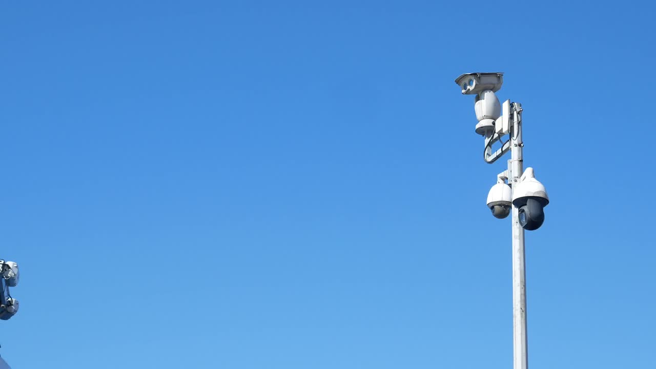 Telecamere di sicurezza su un palo contro un cielo sereno