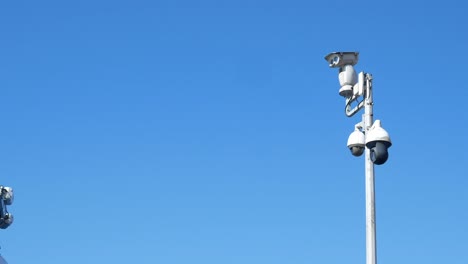 security cameras on a pole against a clear sky