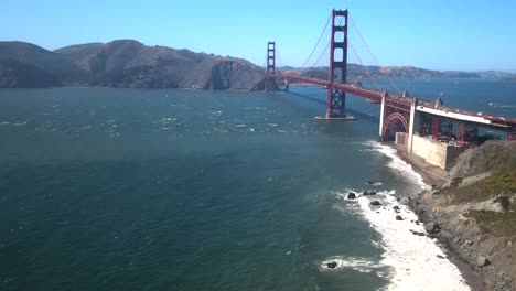 a cinematic aerial drone capture of the san francisco bridge, featuring an unidentifiable perspective of vehicles traversing back and forth across the bridge