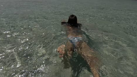 una chica en bikini tropical nadando