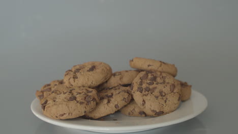 hand taking chocolate chip cookies from pile of cookies - wide