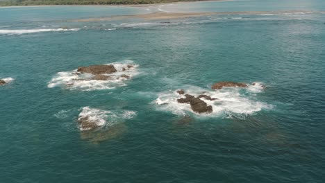 drone aerial of waves crashing on sea stacks in the ocean of costa rica, whale's tail