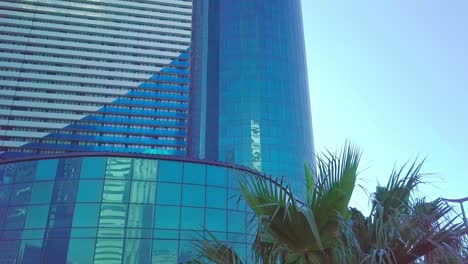 shot of reflections of sun, clouds and sky on glass windows of city skyscraper.