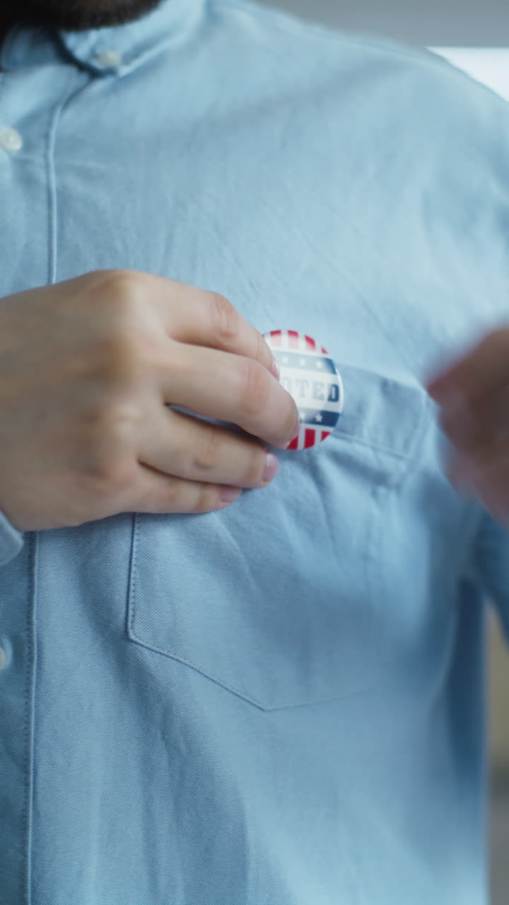 African American us Citizen Puts on Badge with Usa Flag Logo Close up of Anonymous African American Man or us Citizen Putting on Badge with Usa Flag Logo and Inscription i Voted Male Voter at Polling Station after Voting Election Day in the United States