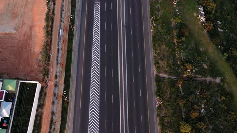 aerial view of a multi-lane highway with adjacent residential community and green landscape