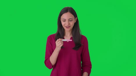 mujer india feliz obtiene su prueba de embarazo pantalla verde positiva