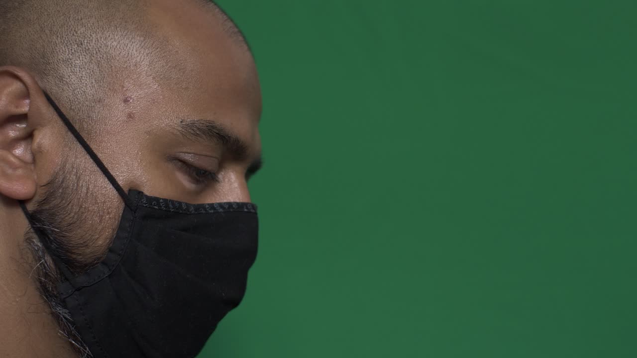 macho adulto con mascarilla mirando hacia abajo