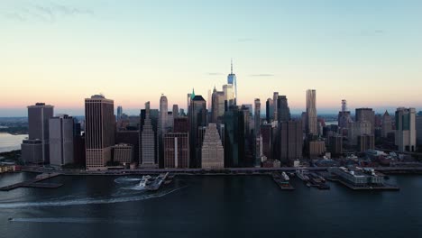 east river, brooklyn bridge and the skyline of lower manhattan, dawn in new york, usa - aerial view