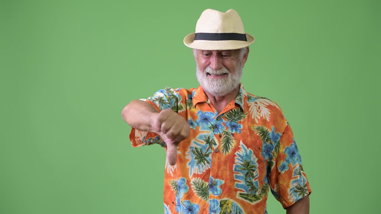 hombre turista barbudo y guapo listo para las vacaciones contra un fondo verde