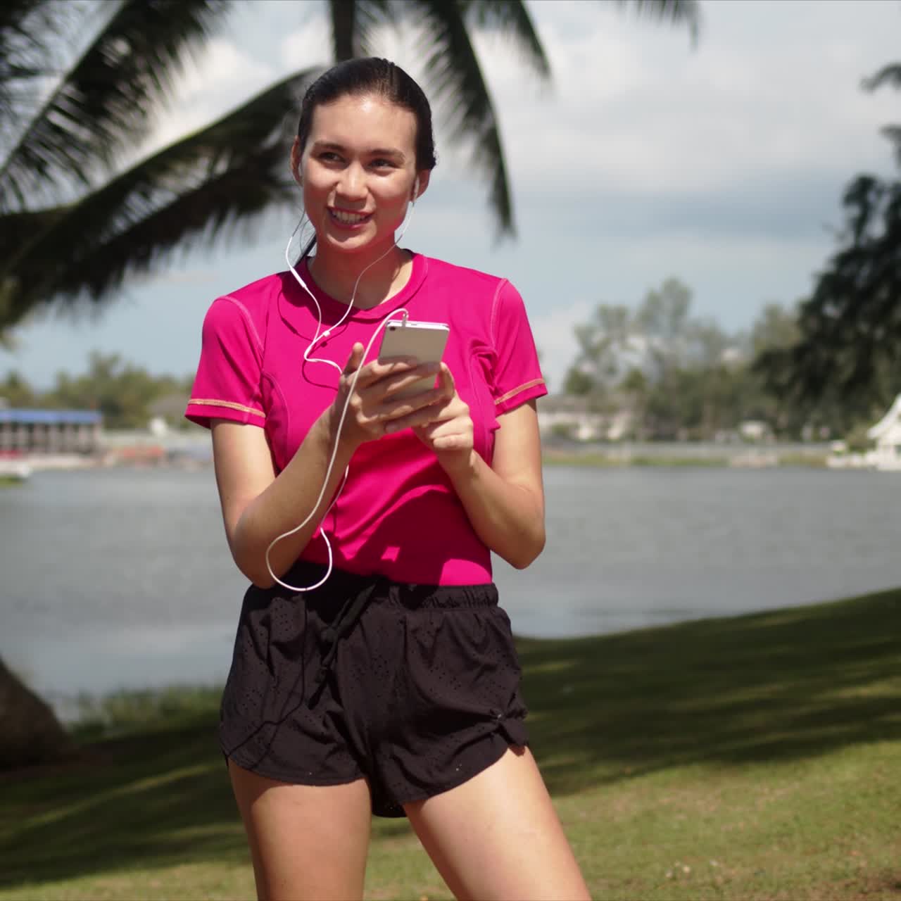 mujer deportiva alegre escuchando música en el teléfono inteligente