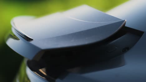 close up shot of a grey luxury sport's car rear spoiler rising