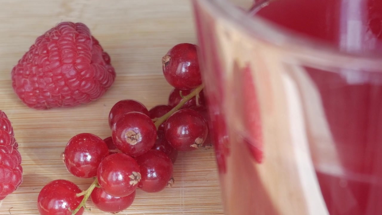 Fresh berry milkshake with raspberries, currants on a wooden table