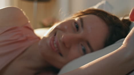 closeup serene woman waking up in morning sunlight. sleepy girl posing in bed