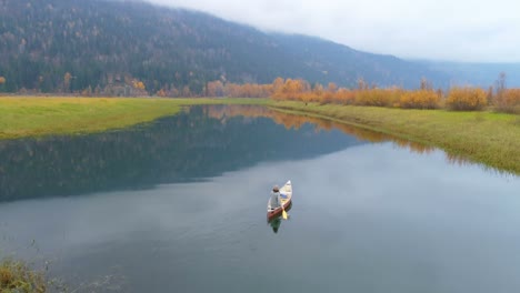 hombre remando un bote con su perro en un lago 4k
