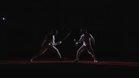 Two fencers compete in a match, one is in a lunge position, the other is facing them