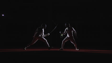 two fencers compete in a match, one is in a lunge position, the other is facing them