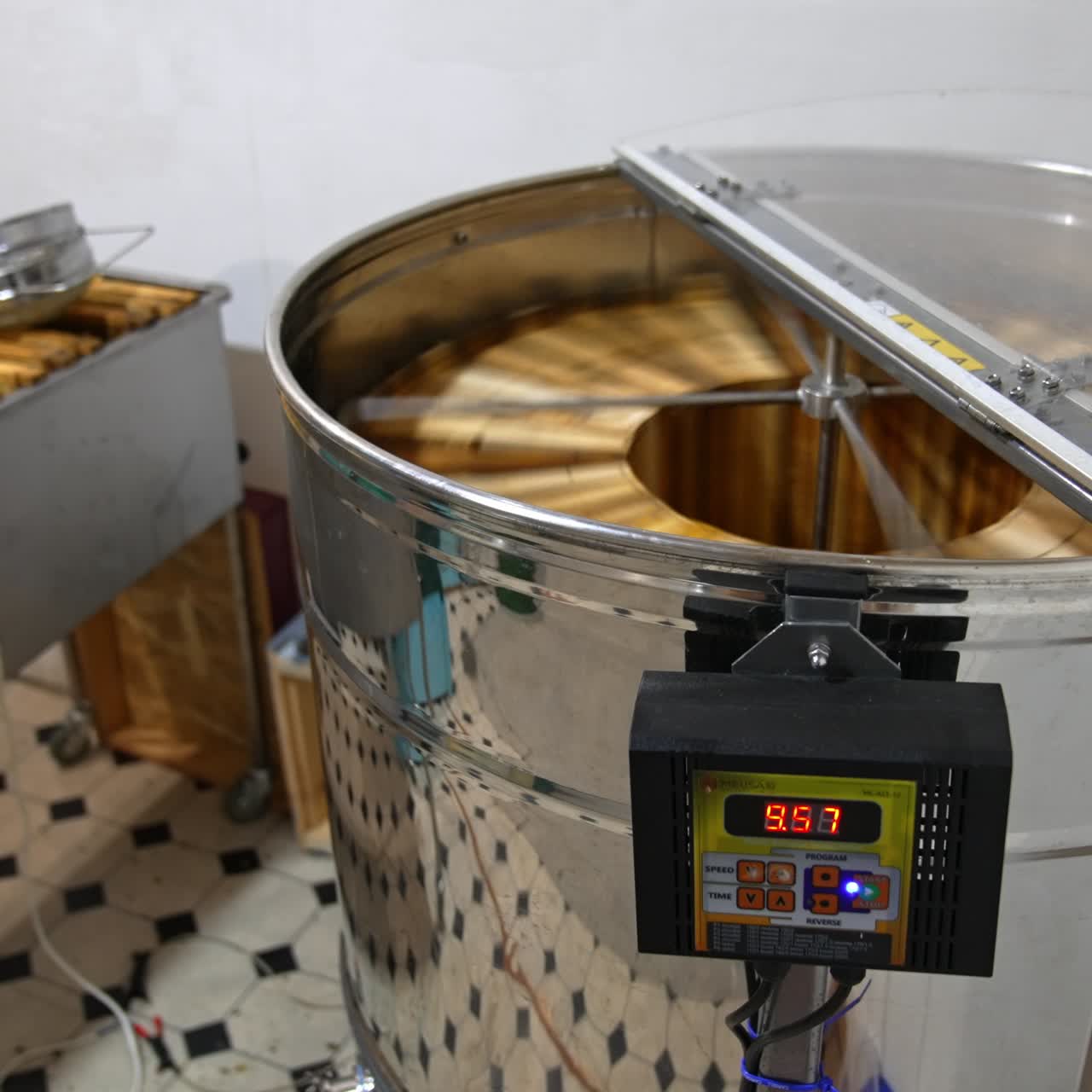 Electric machine with metal carcass working indoors. Honey frames rotating in the apparatus to extract organic product