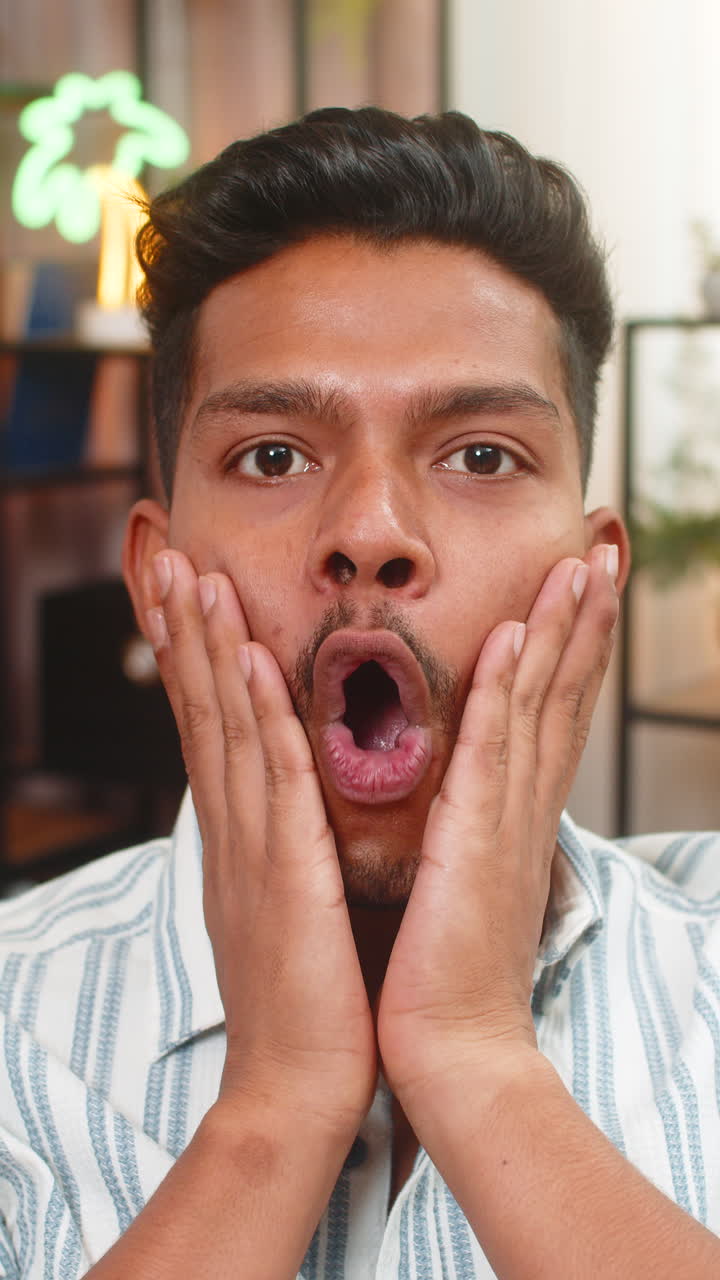 Indian man grabs cheeks and says wow after reading positive news shows big surprise joyful reaction