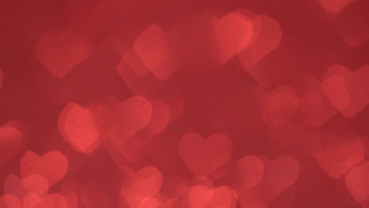 el bokeh en forma de corazón se mueve cíclicamente sobre un fondo rojo.
