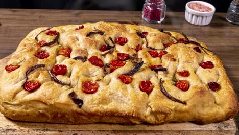 Focaccia-Italiana-Tradicional-Con-Pepperoni,-Tomates-Cherry,-Aceitunas-Negras,-Romero-Y-Cebolla---Focaccia-Casera-De-Pan-Plano