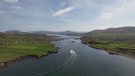 Vídeo-De-Un-Dron-Que-Muestra-Un-Barco-Navegando-Hacia-La-Ciudad-De-Portmagee-En-Kerry,-Irlanda