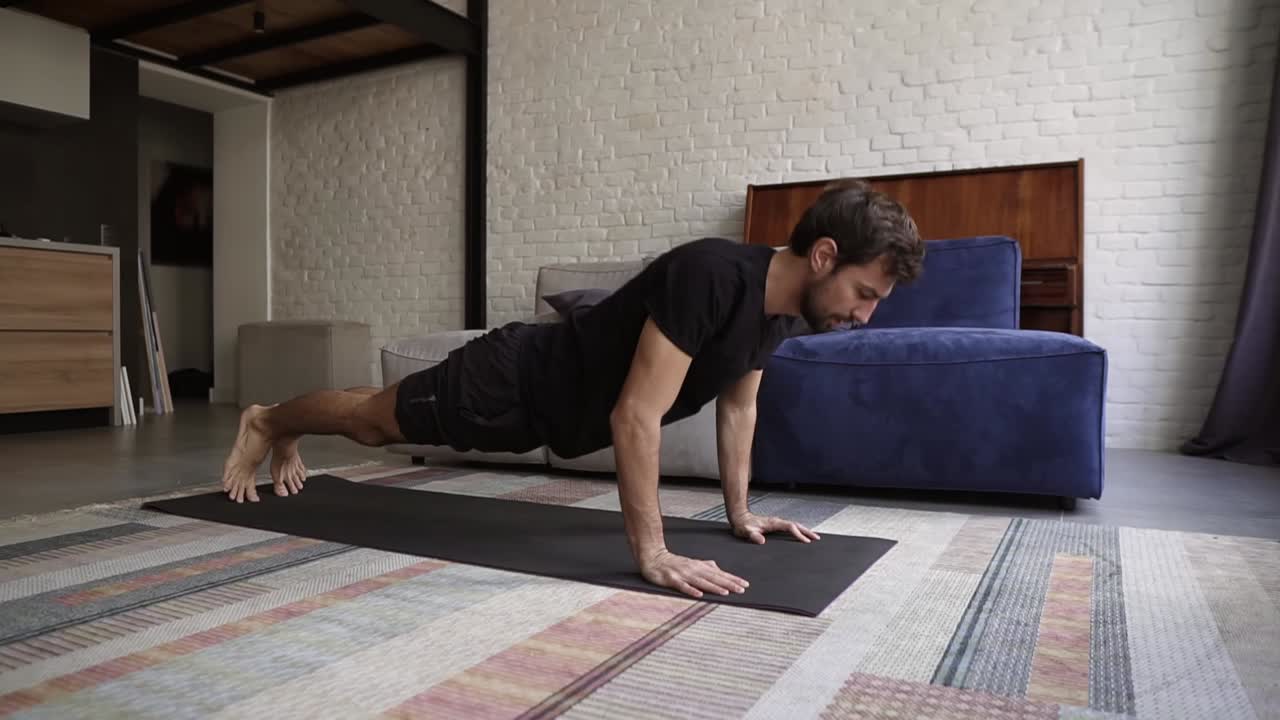 Man holding hands on floor and doing push-up exercise at home