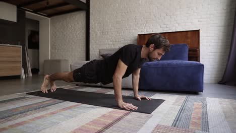 man holding hands on floor and doing push-up exercise at home