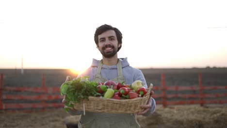 retrato de un feliz joven agricultor sosteniendo verduras frescas en una cesta