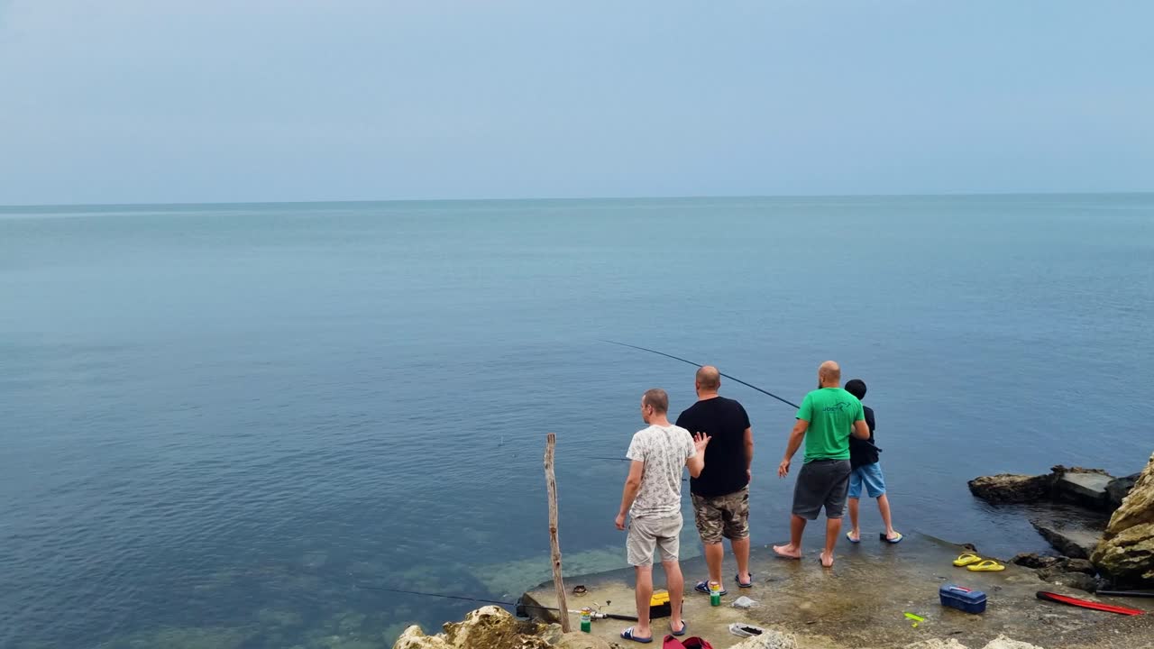 Four men fishing in black sea on an overcast day in summer in Balchik Bulgaria