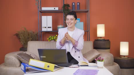 home office worker young woman makes a trust sign to the camera.