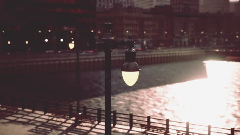 a street lamp on a waterfront at sunset