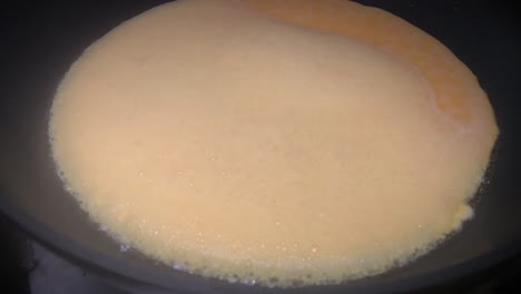 a plain omelet or omelette cooking into a frying pan