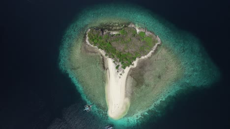 rising top down drone shot of an isolated island in the philippines.