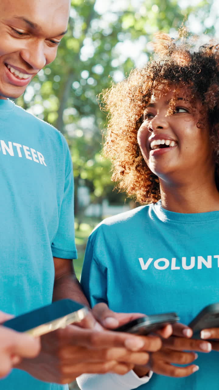 Happy Young Volunteers Using Smartphones Outdoors
