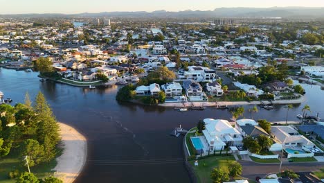 drone captures luxury homes along gold coast canals at sunset. smooth camera movement highlights vibrant colors and serene atmosphere