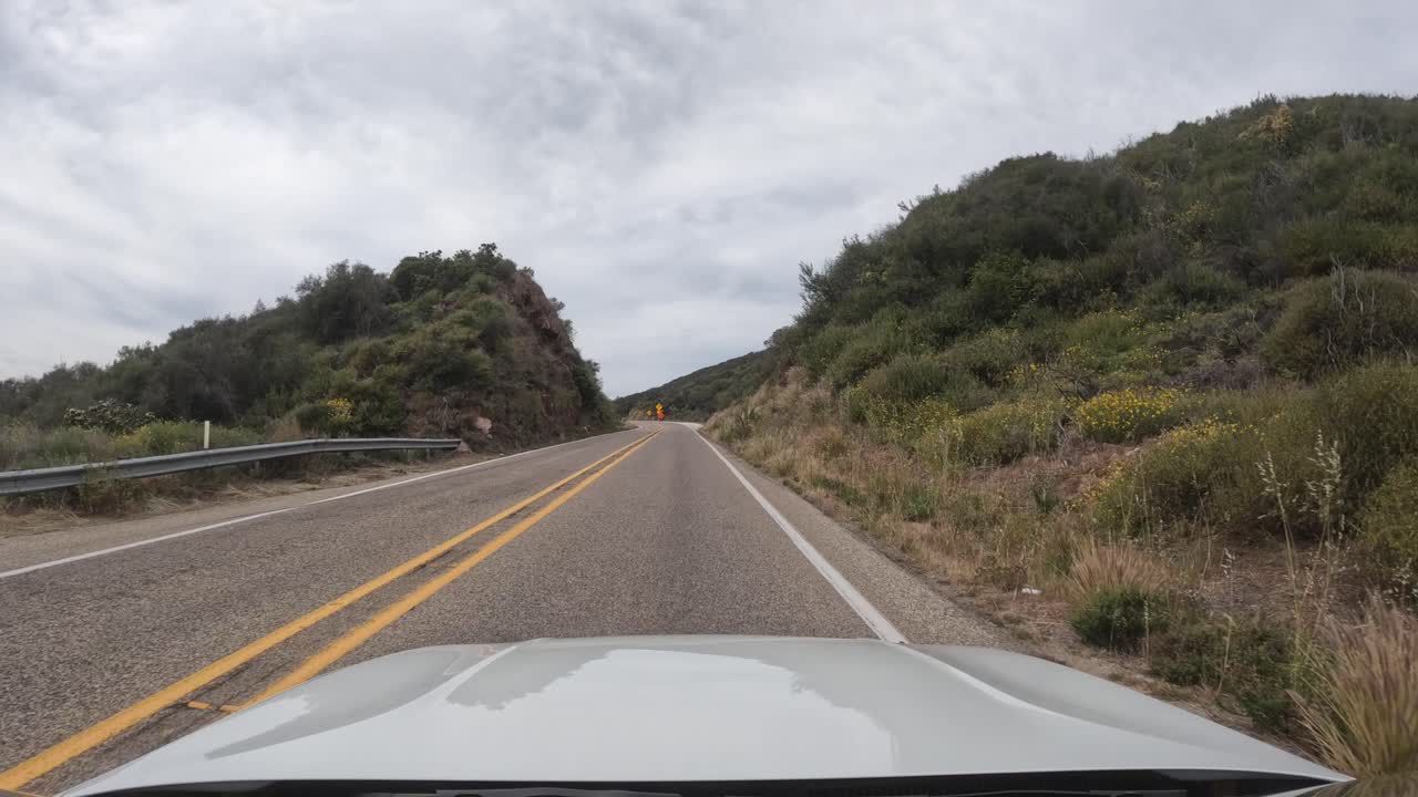 Guidando lungo una strada di campagna attraverso un terreno aspro e roccioso nella Foresta Nazionale Los Padres - punto di vista del conducente.