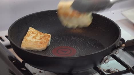 Frying-cheese-on-a-pot-and-flipping-it-with-pincers