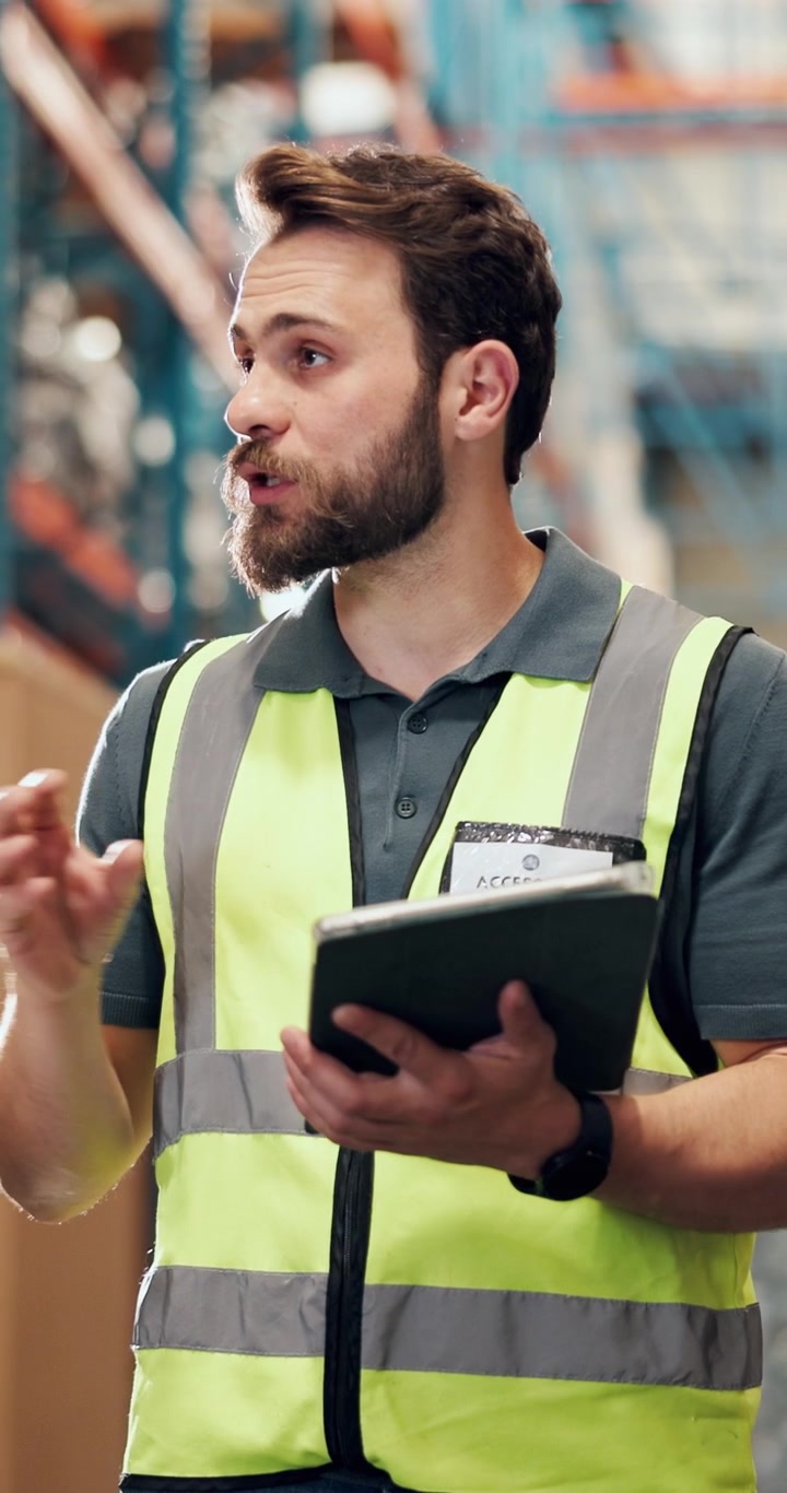 Responsabile di magazzino che discute dell'inventario utilizzando un tablet digitale