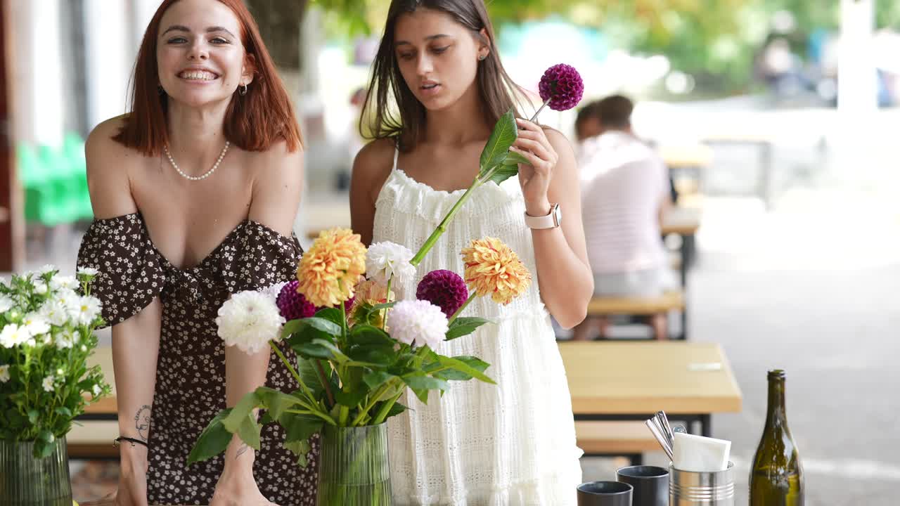 mujeres admirando un arreglo floral