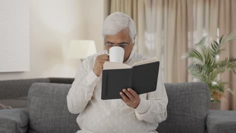 Indian-old-man-reading-book-and-drinking-tea