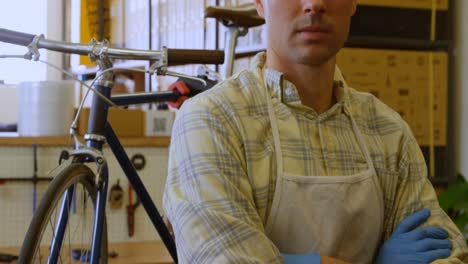 Man-standing-with-arms-crossed-in-workshop-4k