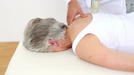 médico masajeando los hombros de los pacientes ancianos