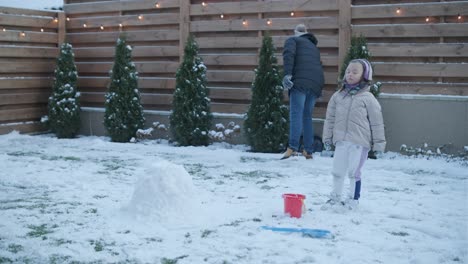 grandfather and granddaughter having fun in the snow